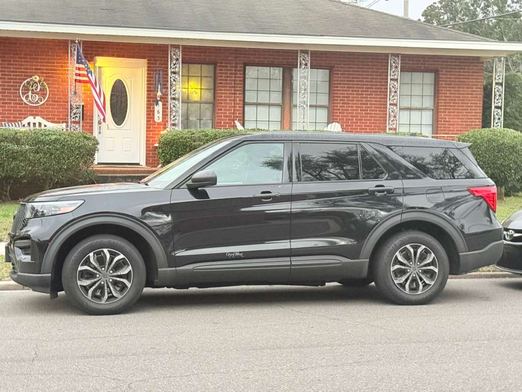 Black Ford Explorer Police Interceptor parked at residential home on 163 Peter Street, Biloxi. Tiny cursive City of Biloxi decal barely visible on rear quarter panel — black on black.